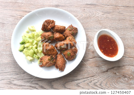deep fried grouper fish patty on plate with slice cucumber dipping sweet chili sauce  127450407