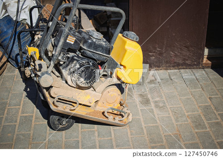 Construction equipment sits on the ground during a project at a construction site in the daytime 127450746