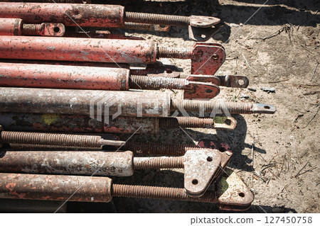 Metal scaffolding poles stacked on construction site during daylight hours Metal scaffolding poles stacked on construction site during daylight hours 127450758