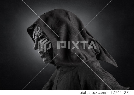 Scary figure with hooded cloak over dark misty background with clipping path 127451271