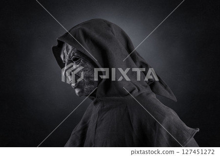 Scary figure with hooded cloak over dark misty background with clipping path 127451272