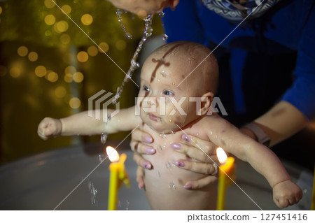 Orthodox baptism of a child. Church rite of acceptance of faith. The child is bathed at baptism. Orthodox baptism of a child. Church rite of acceptance of faith. The child is bathed at baptism. 127451416