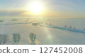 Aerial view of cold winter landscape arctic field, trees covered with frost snow, ice river and sun rays over horizon. Extreme low temperature weather. 127452008