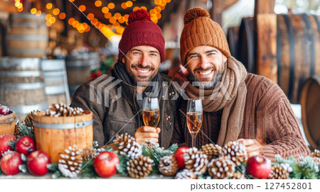 Two men celebrating winter holidays with drinks in cozy outdoor setting surrounded by decorations 127452801
