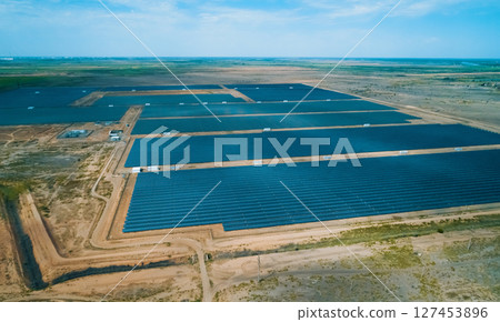 Solar energy farm located in a vast arid landscape generating renewable energy under clear blue skies Solar energy farm located in a vast arid landscape generating renewable energy under clear blue skies 127453896
