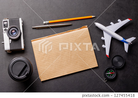 Creative flat lay of a travel-themed desk with notepad for plans 127455418