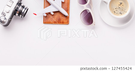Travel-themed flat lay with toy airplane, camera, and coffee Travel-themed flat lay with toy airplane, camera, and coffee 127455424