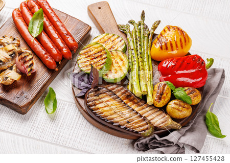 Assorted grilled vegetables including bell peppers, zucchini, eggplant, and sausages 127455428