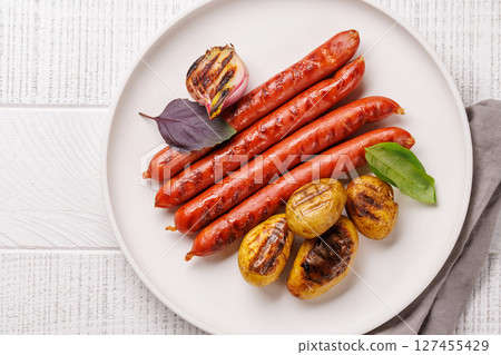 Grilled sausages served with roasted baby potatoes 127455429