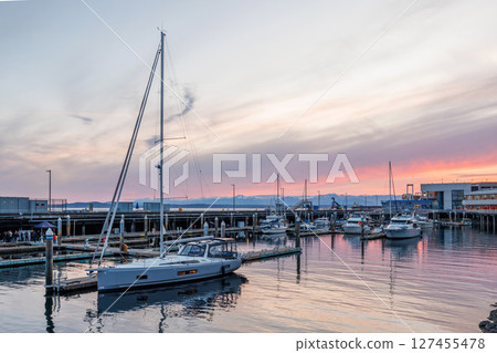 Seattle harbor during sunset with calm water, and silhouettes of boats 127455478