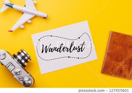 Travel-themed flat lay with blank photo card, camera, toy airplane, and passport 127455601