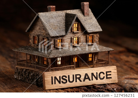 A detailed miniature wooden house is showcased on a rustic surface with warm lights glowing from its windows. A detailed miniature wooden house is showcased on a rustic surface with warm lights glowing from its windows. 127456231