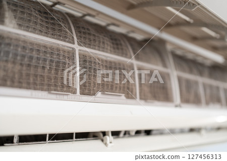 Dirty in dust and mold air conditioner filter close-up. Home air conditioner maintenance 127456313