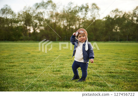 Cute little boy in aviator glasses is standing on the summer field 127456722