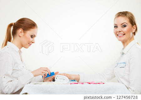 Beautician with client at beauty salon. Beautician with client at beauty salon. 127456728
