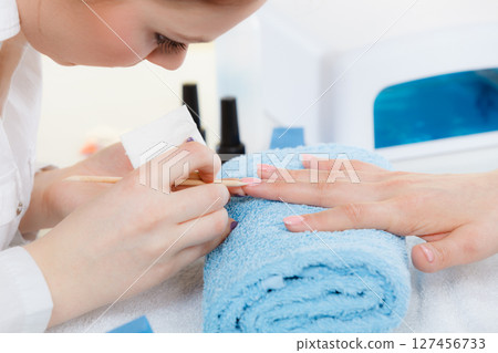 Beautician preparing nails before manicure, pushing back cuticles Beautician preparing nails before manicure, pushing back cuticles 127456733