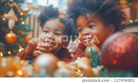 Two joyful children playing with Christmas ornaments surrounded by festive decorations 127456801