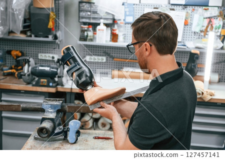 Measuring the prosthesis. Technician working in modern laboratory 127457141