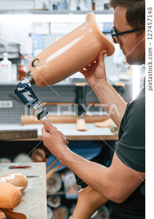 Checking the movement ability of product. Technician working with prosthesis in modern laboratory 127457148