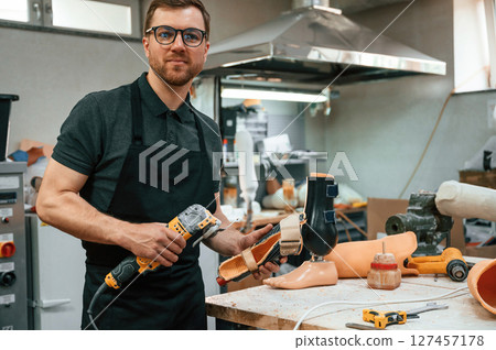 With drill. Technician working with prosthesis in modern laboratory 127457178