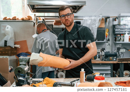 Almost finished product in hands. Technician working with prosthesis in modern laboratory Almost finished product in hands. Technician working with prosthesis in modern laboratory 127457181