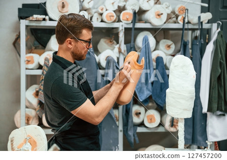 Marks the line with a marker. Technician working with prosthesis part in modern laboratory 127457200