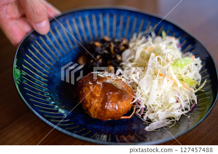 Close-up of a Japanese home-style meal of carefully arranged hamburger steak and shredded cabbage Close-up of a Japanese home-style meal of carefully arranged hamburger steak and shredded cabbage 127457488