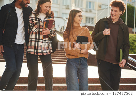 Front view. Four young students in casual clothes are together outdoors 127457562