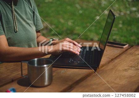 Woman Working Remotely on Laptop Outdoors Embracing Digital Lifestyle 127458002