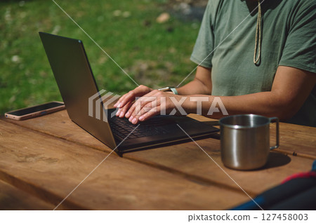Remote Work Lifestyle of a Woman in Outdoor Nature Setting with Laptop 127458003