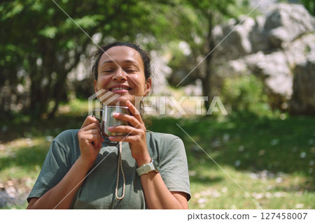 Relaxed Woman Enjoying a Refreshing Experience in a Serene Outdoor Setting Relaxed Woman Enjoying a Refreshing Experience in a Serene Outdoor Setting 127458007