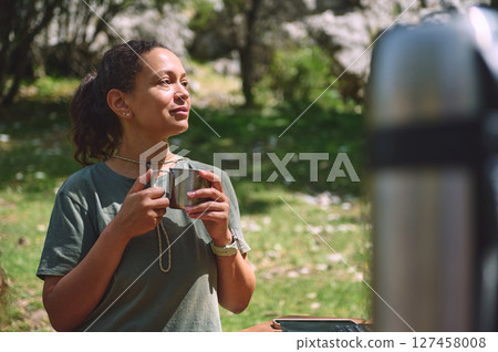 Woman Enjoying a Peaceful Break Outdoors with Coffee in a Scenic Natural Setting Woman Enjoying a Peaceful Break Outdoors with Coffee in a Scenic Natural Setting 127458008