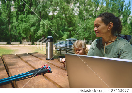 Woman Working Remotely in Nature With Child at Scenic Outdoor Park 127458077