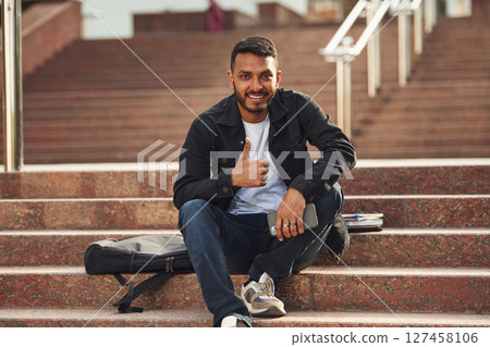 Handsome Indian student is outdoors 127458106