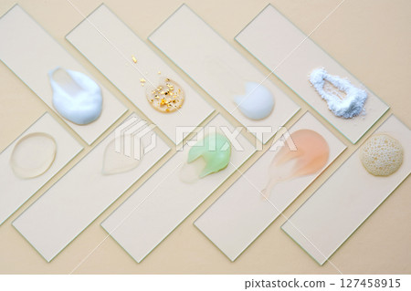 Samples of multi-colored cosmetic products on a beige background. Samples of multi-colored cosmetic products on a beige background. 127458915