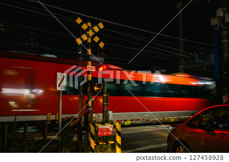 Odakyu Line at night: Romancecar passing through a railroad crossing 127458928