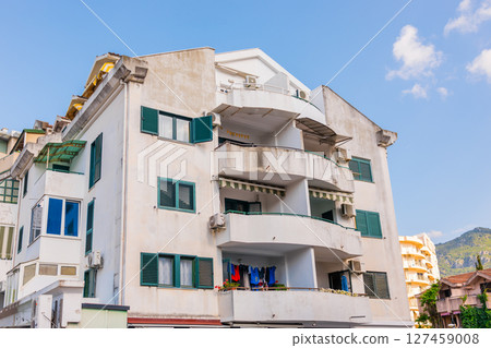 Old residential building with open balconies and laundry drying. Urban housing, daily life, and Mediterranean lifestyle in coastal city. 127459008