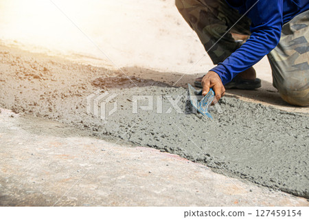 Workers are plastering at the construction site. 127459154