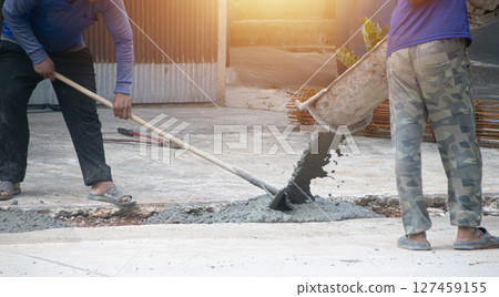 Workers are pouring cement at the construction site. 127459155