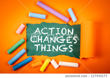 ACTION CHANGES THINGS Concept with Torn Paper and Colorful Chalk on Orange Background ACTION CHANGES THINGS Concept with Torn Paper and Colorful Chalk on Orange Background 127459175