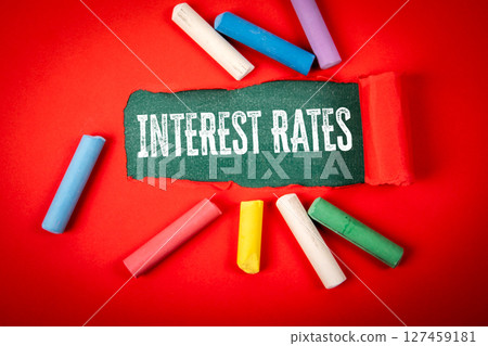 INTEREST RATES Concept with Torn Paper and Colorful Chalk on Red 127459181