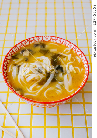 plate of noodles and chopsticks. vegetable ramen in a bright blue plate. Asian dishes. 127459358