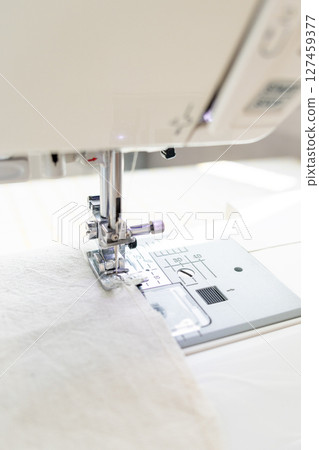 sewing machine with a cloth under a steel needle. manufacture of clothing. sewing machine with a cloth under a steel needle. manufacture of clothing. 127459377