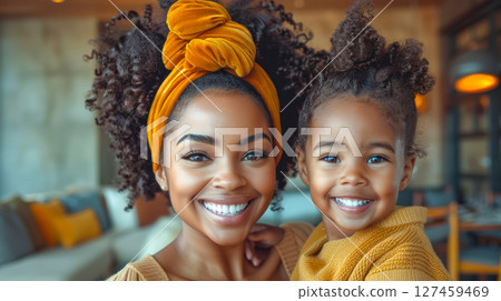 Smiling African American mother and daughter enjoying quality time together indoors 127459469