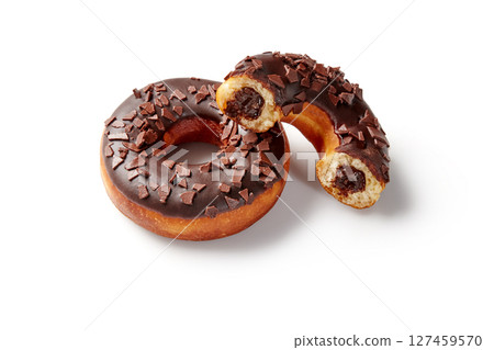 Two chocolate donuts with chocolate filling and shavings on white background Two chocolate donuts with chocolate filling and shavings on white background 127459570