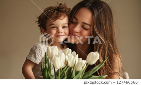 Mother Enjoying a Tender Moment With Her Smiling Child and a Bouquet of Tulips Indoors 127460560