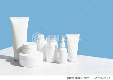 Blank cosmetic containers on light blue background 127460573