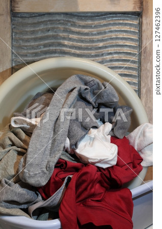 A basin with dirty laundry on the washing board. A basin with dirty laundry on the washing board. 127462396