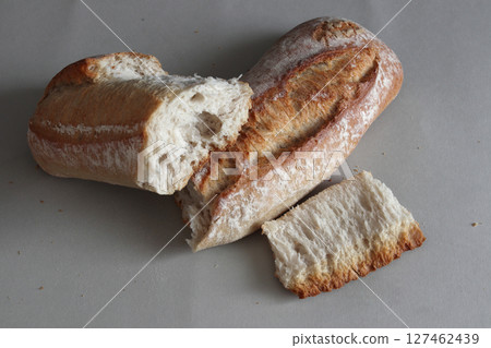 A broken freshly baked rustic baguette. A broken freshly baked rustic baguette. 127462439