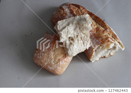 A broken freshly baked rustic baguette. A broken freshly baked rustic baguette. 127462443